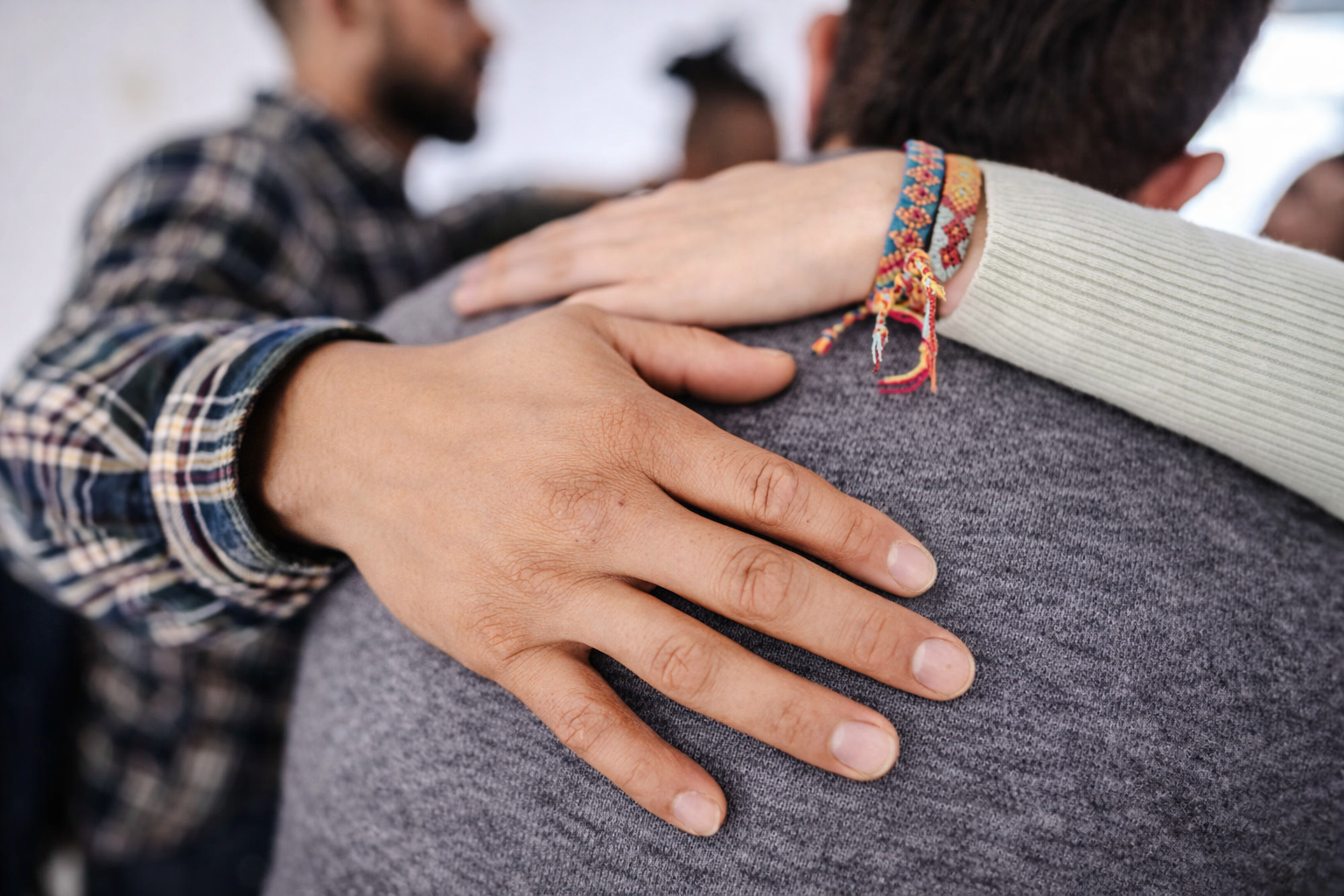 mão apoiando outra pessoa em gesto de cuidado — consolados para consolar