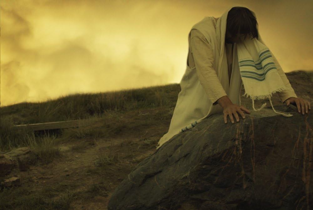 Imagem de uma pessoa sentada em cenário árido, representando os atalhos e a tentação de Jesus no deserto