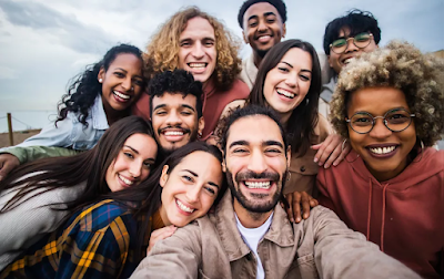Grupo de pessoas de diferentes idades e etnias reunidas e sorrindo para uma foto.